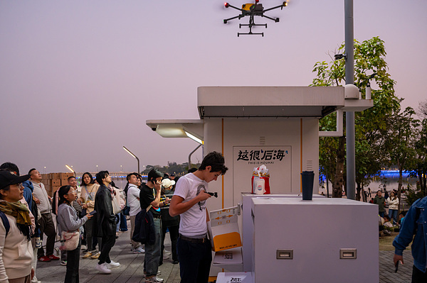 在深圳，外國游客體驗無人機外賣送餐。