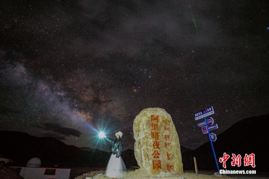 圖為6月20日晚，游客“打卡”西藏阿里暗夜公園，天上是銀河與流星（右上角）。曹枝清 攝